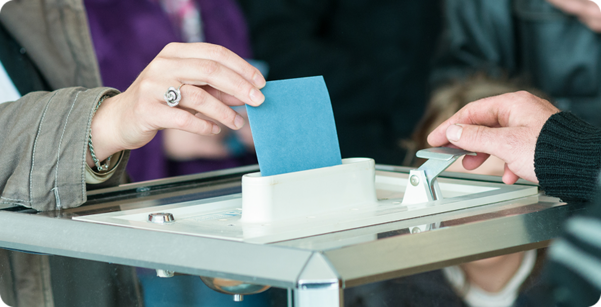 Wahlzettel wird in Urne geworfen